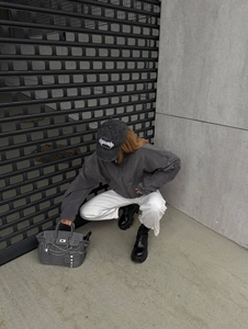 Street style shot of dark grey fleece hoodie with letter embroidery and grey plush tote bag