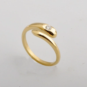 Macro detail of 18K gold snake wrap ring featuring a minimalist diamond accent on band