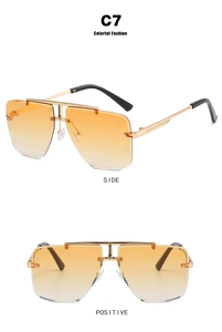 Detail view showing frameless gradient orange lenses and golden metal temples of sunglasses