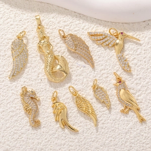 Vue détaillée des breloques DIY dorées avec ailes, hippocampe et oiseaux sertis de zircon