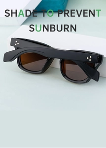 Detail of black sporty sunglasses with brown lenses and gold star rivets on a green stand