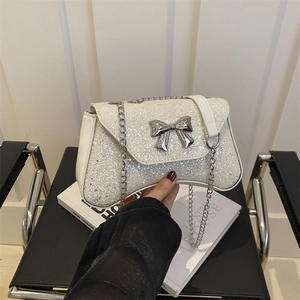 White glittering evening clutch bag with a silver bow knot and elegant chain strap