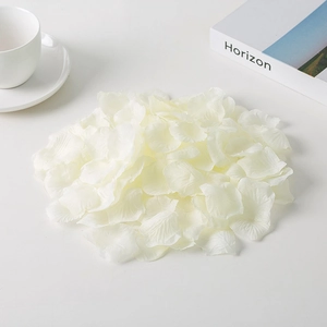 Close-up of scattered white non-woven silk rose petals for wedding and event decor