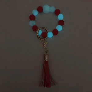 Bracciale portachiavi in silicone luminoso con nappe rosse e anello in metallo dorato
