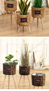 Detail of woven straw plant pots with wooden stands in light and dark brown finishes