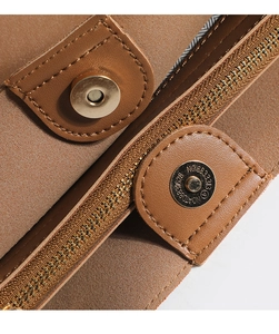 Detail of brown matte leather bucket bag featuring a magnetic buckle and gold metal zipper