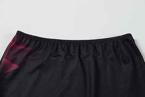 Détail de la taille élastique et de l'imprimé rouge sur le tissu de la jupe longue