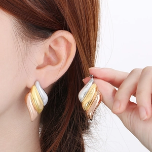 Detailed view of tricolor leaf earrings featuring gold silver and rose gold striped textures