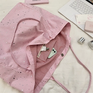 Top view of pink star canvas tote bag interior with striped lining and storage capacity