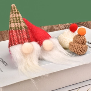 Nahaufnahme von Mini-Strickmützen und Plüschzwergen mit festlichen Streifendetails