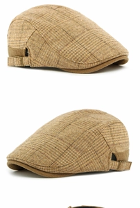 Detail view of vintage brown plaid newsboy cap with metal buckle and wool texture