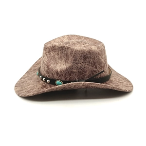 Detail of vintage brown cowboy hat featuring crackle texture and turquoise studded band