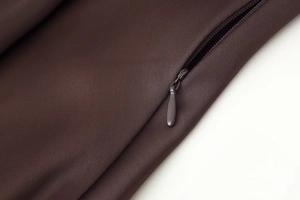 Detailed close-up of high-quality invisible zipper on dark brown satin scarf dress