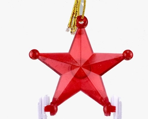 Close-up of a translucent red star ornament with a gold string for Christmas tree decor