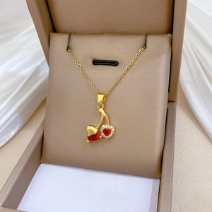 Detailed view of cherry pendant necklace with red heart stone and pavé crystals