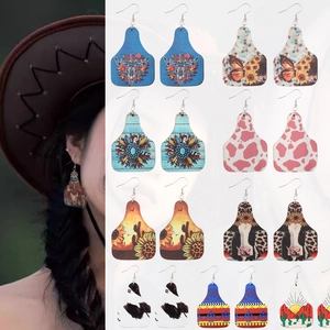 Detailed views of western cow tag earrings featuring sunflower and desert prints