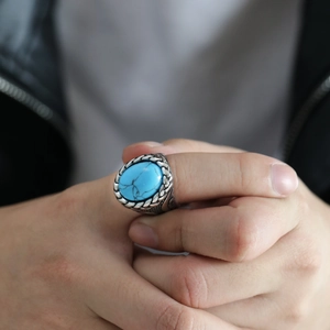 Detail shot of men's vintage oval turquoise ring with woven pattern steel band
