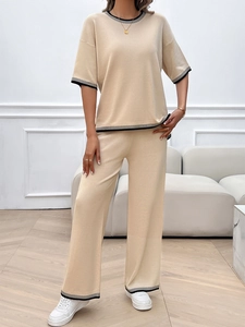 Détail de l'ensemble beige en maille avec rayures contrastées sur le haut et le pantalon