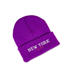 Detailed close-up of dark purple knit beanie featuring white NEW YORK embroidery and text