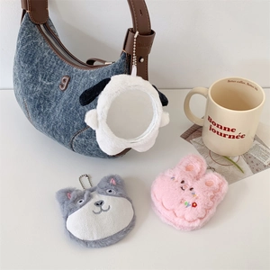Cute plush cartoon animal keychain charms including dog and rabbit on a table