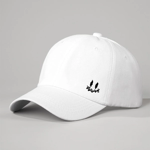 Detail of white cotton baseball cap showing side smile embroidery and fabric texture