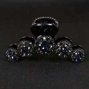 Elegante pinza per capelli nera con strass blu scuro scintillanti e design curvo raffinato