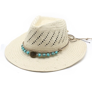 Detail of hand-woven straw hat featuring ethnic beaded band and vintage sun metal charm