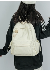 Detail der Cord-Rucksack-Struktur mit süßen Bärenanhängern und Reißverschlusstasche