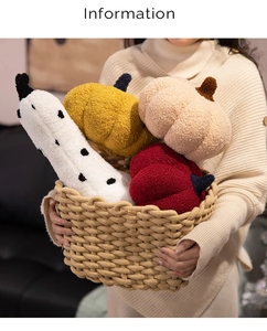 Detail of soft sherpa pumpkin plush toys in assorted colors held in a rustic basket