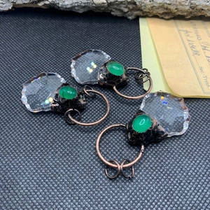 Detail of vintage bronze maple leaf pendants with green agate and crystal in retro setting