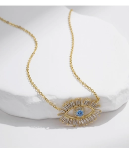 Detailed view of S925 silver blue evil eye pendant necklace on white stone display