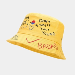 Détail d'un bob en coton jaune avec texte de graffiti de rue noir et rouge artistique