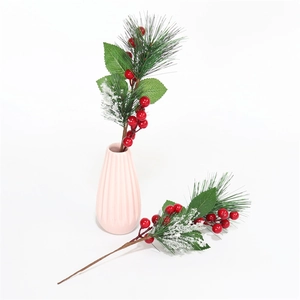 Ramo di Natale artificiale con bacche rosse e foglie di pino innevate in vaso