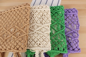 Flat lay of woven cotton rope handbags in camel, beige, green, and purple colors