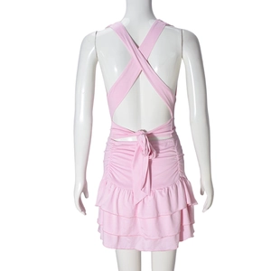 Detail of pink backless dress showing cross straps and tiered ruffle skirt on mannequin