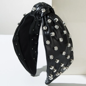 Detail of black faux leather headband featuring top knot and inlaid sparkling rhinestones