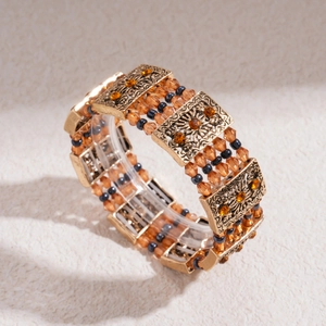 Detail of vintage gold bracelet with amber crystals and intricate floral engravings