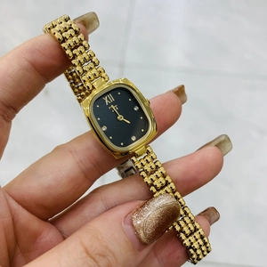 Dettaglio dell'orologio in acciaio dorato con quadrante nero e indici di diamanti