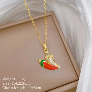Macro detail of red chili pendant with crystal inlay on a gold titanium steel chain