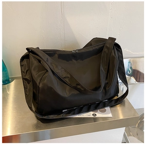 Detail of durable black nylon fabric and metallic zipper on a large capacity gym bag