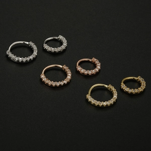 Macro shot of 20G copper septum rings with paved zircon in silver, gold and rose gold