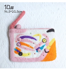 Detail of handmade wool felt bag with colorful patchwork and beaded floral accents