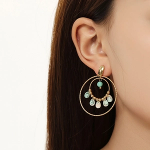Detail shot of French style gold hoop earrings with pastel resin charms and pearl accents