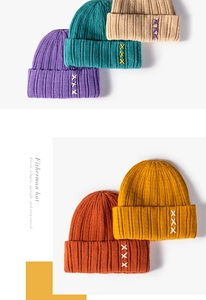 Detailed view of ribbed knit beanies with cross-stitch embroidery in various colors