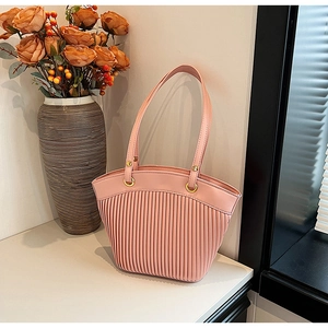 Detail of pink striped pleated tote bag with golden metal rings and slim handles