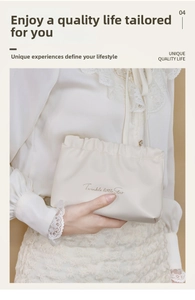 Close-up of cream white ruffled cosmetic bag with Twinkle Little Star lettering