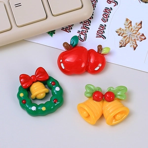 DIY Christmas resin charms featuring red apple, green wreath, and yellow bells for crafting