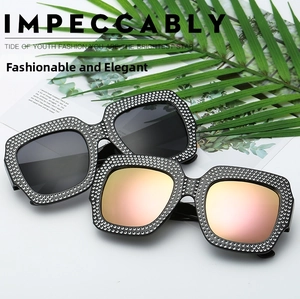 Fashionable oversized sunglasses with crystal-encrusted frames and reflective mirror lenses