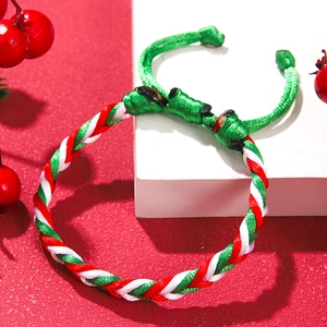 Detailed view of red, green, and white woven Christmas bracelet with adjustable cord