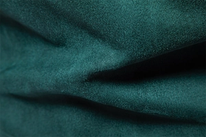 Detailed macro view of dark green faux suede fabric with soft brushed texture